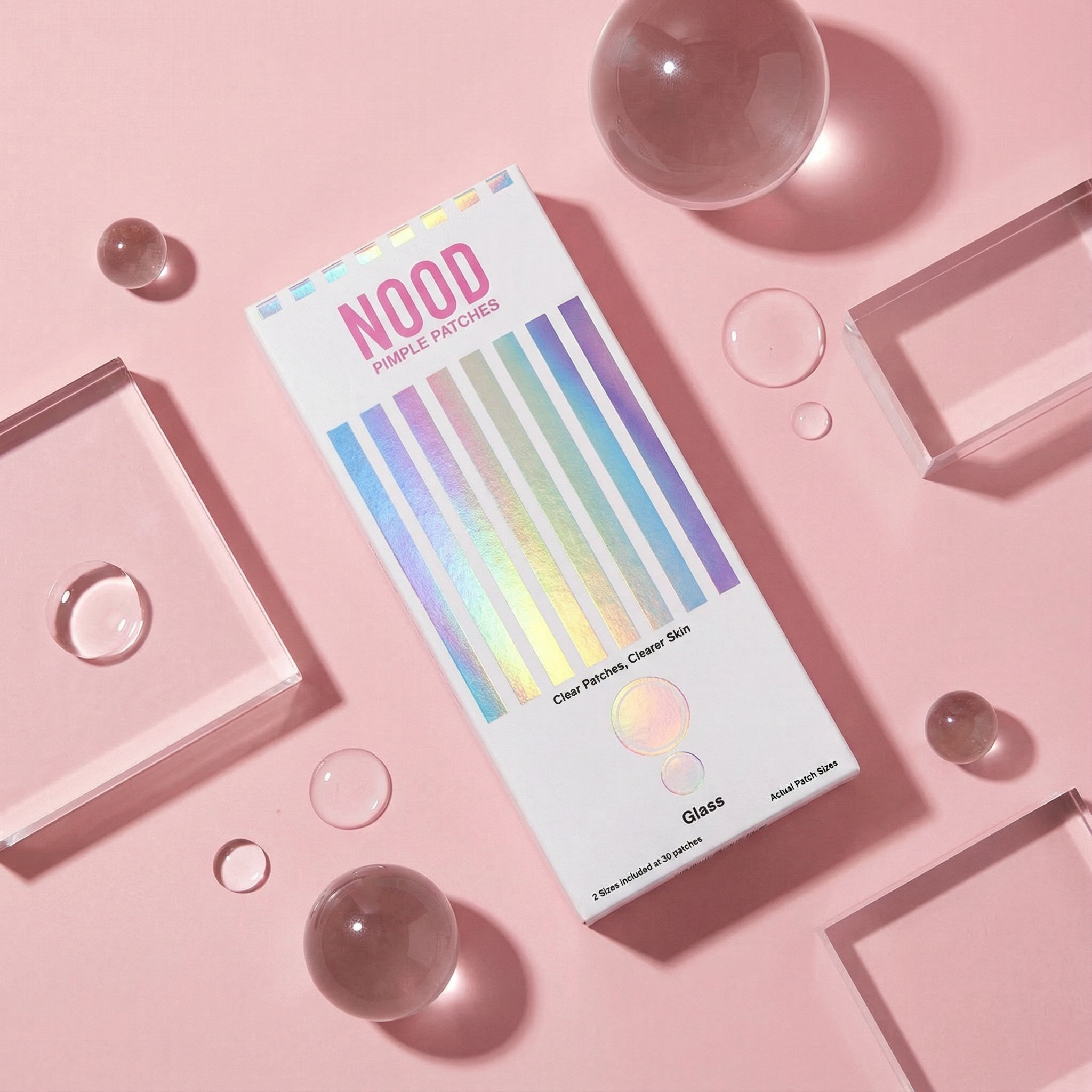 Box of Nood purple patches on a pink background with clear spheres and geometric shapes.